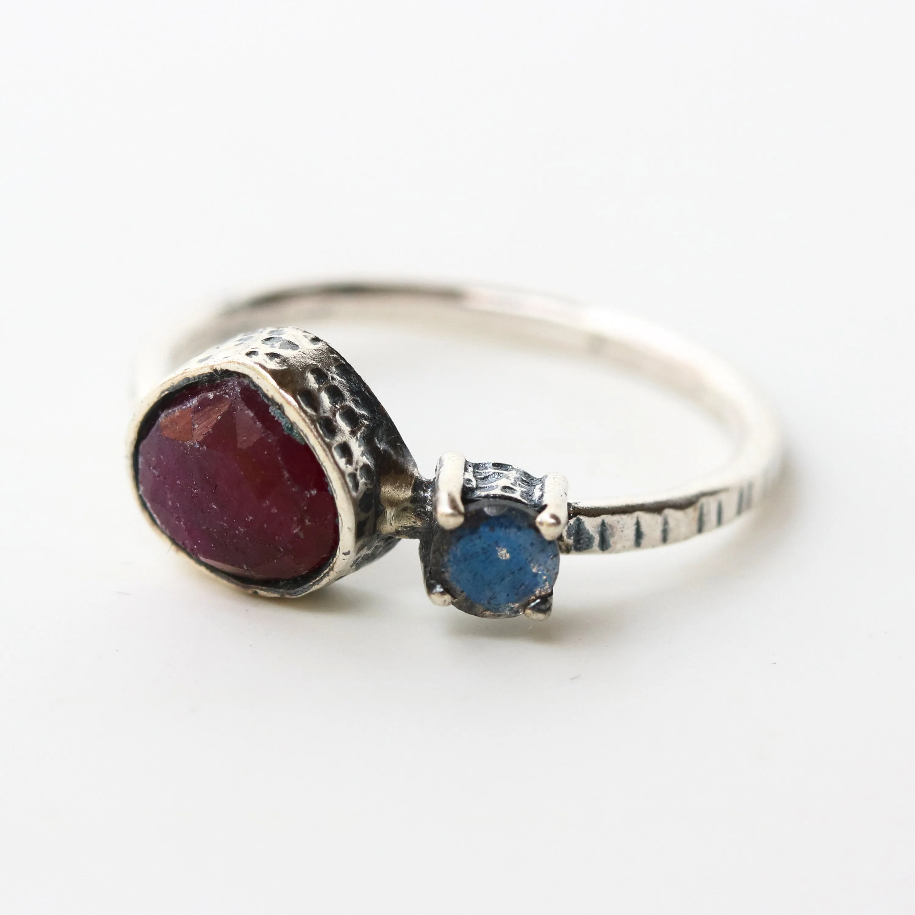 Deep red ruby ring in silver bezel setting and tiny round labradorite with sterling silver texture design band