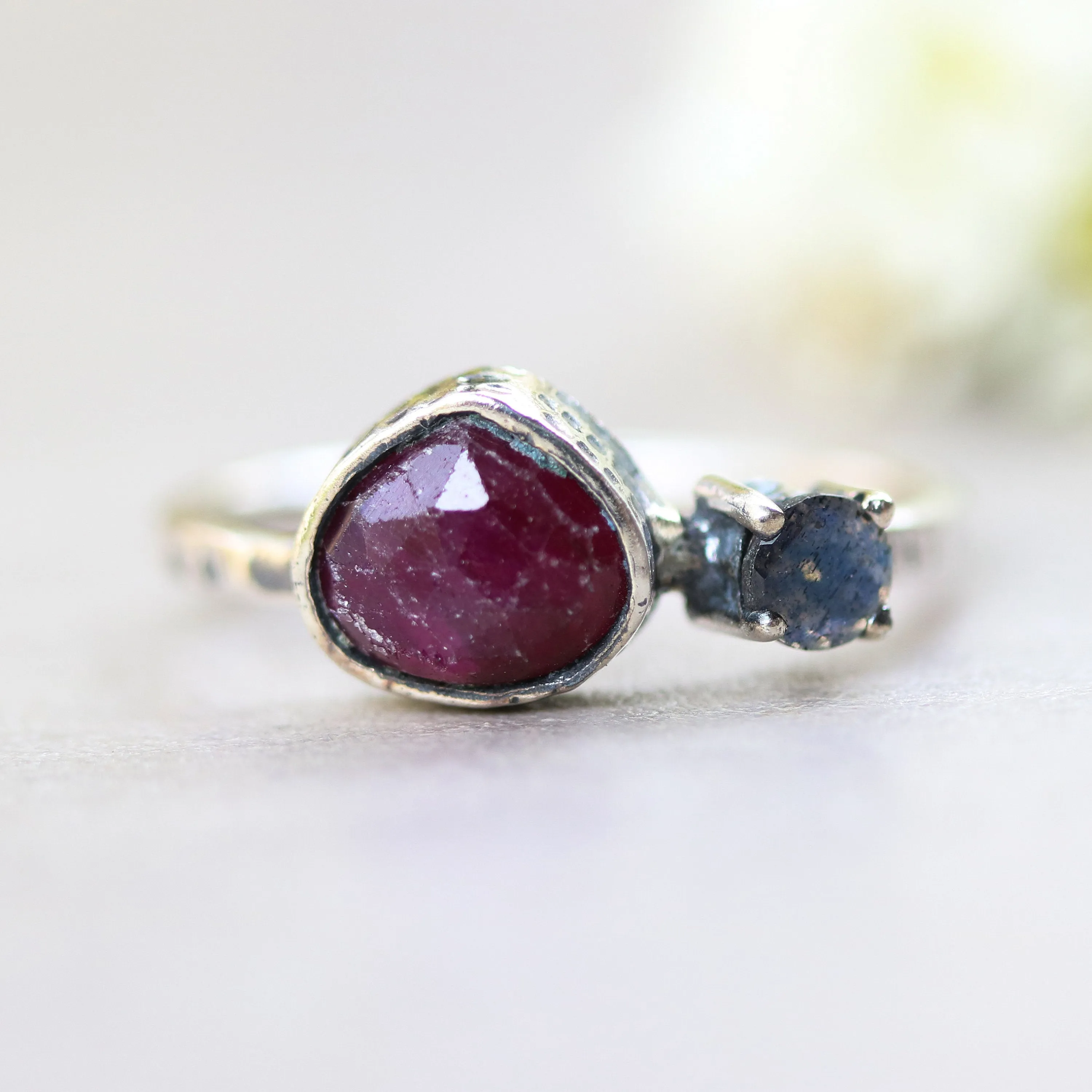 Deep red ruby ring in silver bezel setting and tiny round labradorite with sterling silver texture design band