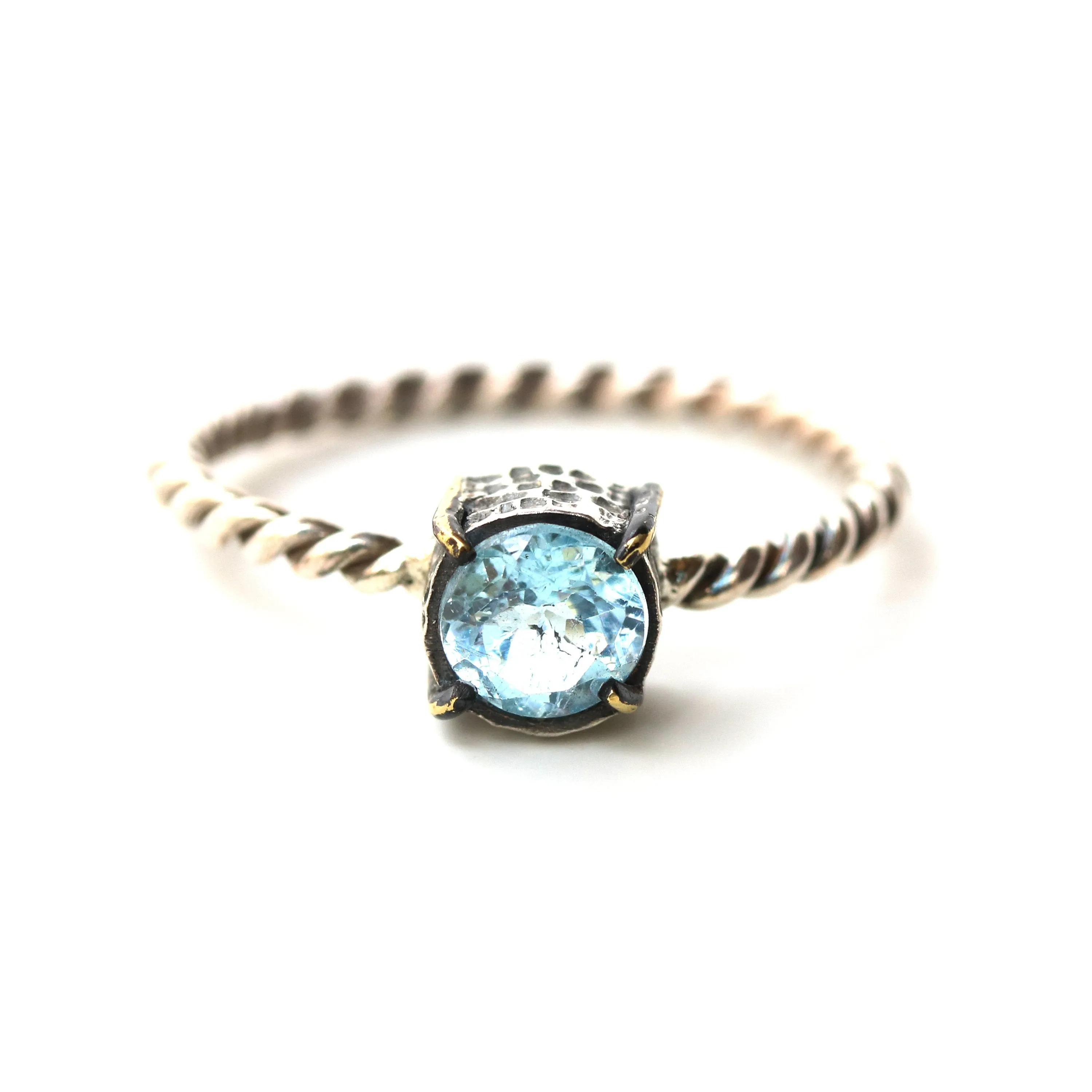 Round faceted blue topaz ring in silver bezel and brass prongs setting with sterling silver twist design band