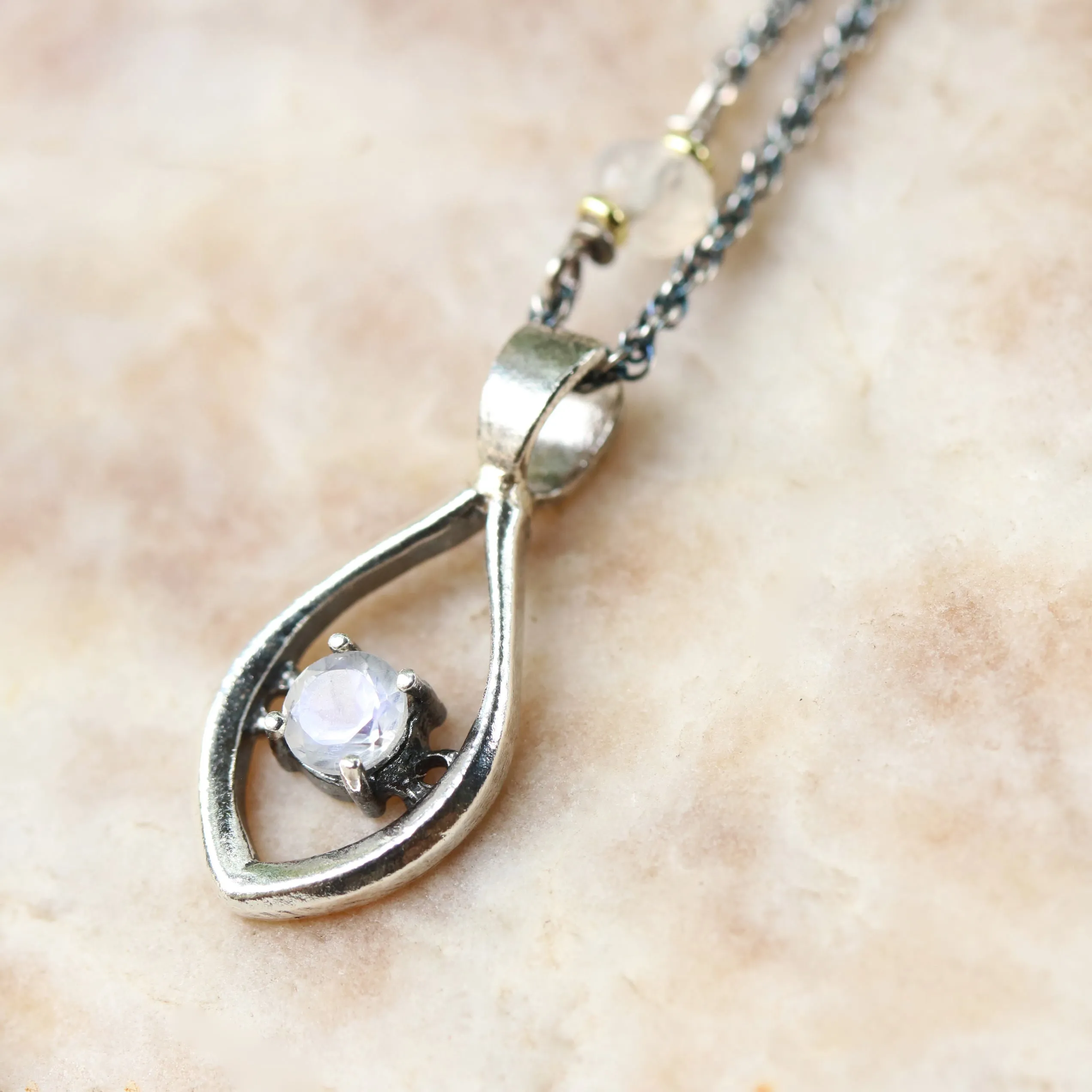 Silver leaf shape necklace and round faceted moonstone at the center with moonstone beads secondary on oxidized sterling silver chain