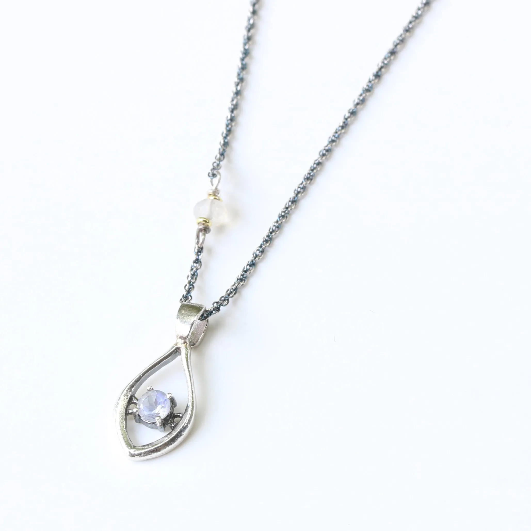 Silver leaf shape necklace and round faceted moonstone at the center with moonstone beads secondary on oxidized sterling silver chain