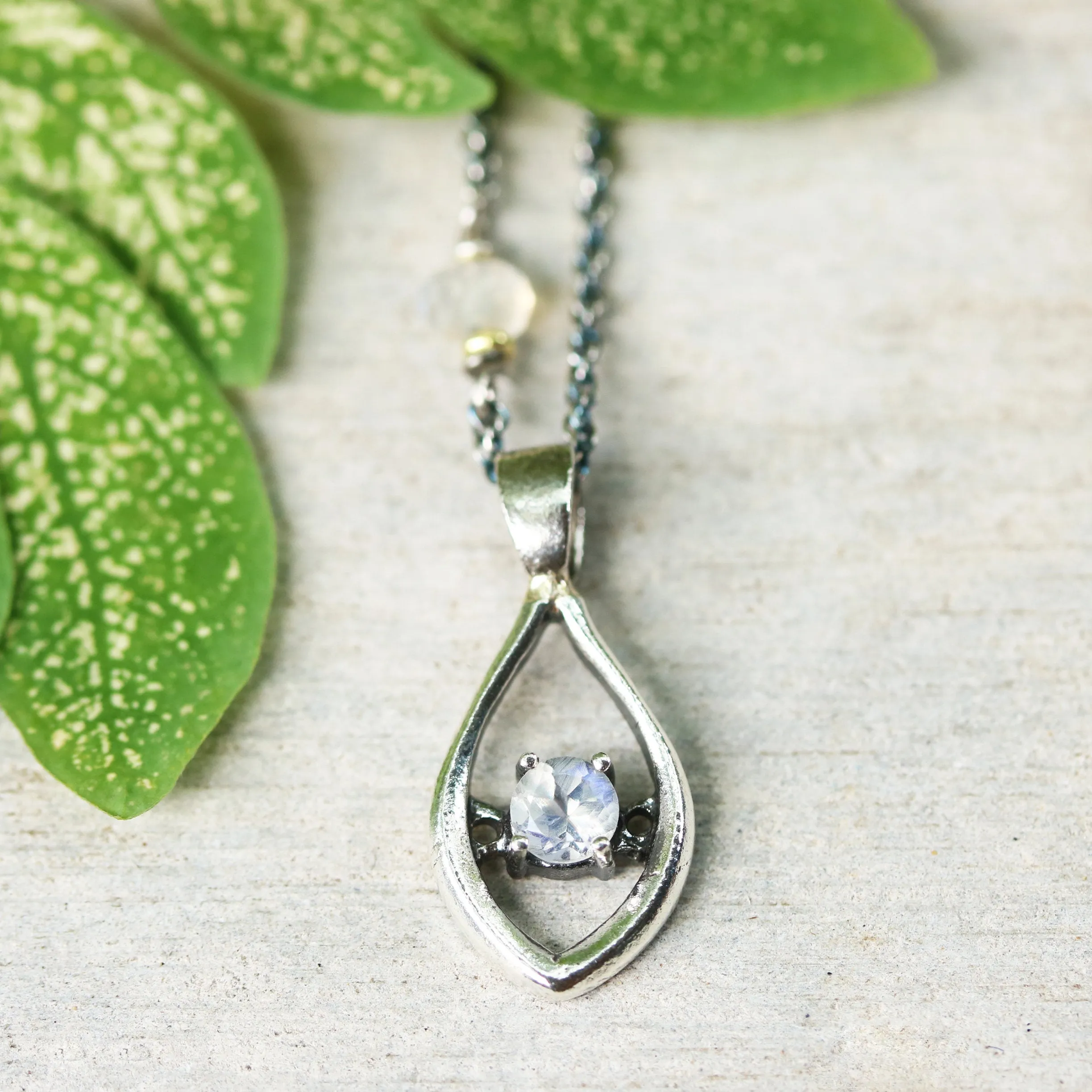 Silver leaf shape necklace and round faceted moonstone at the center with moonstone beads secondary on oxidized sterling silver chain