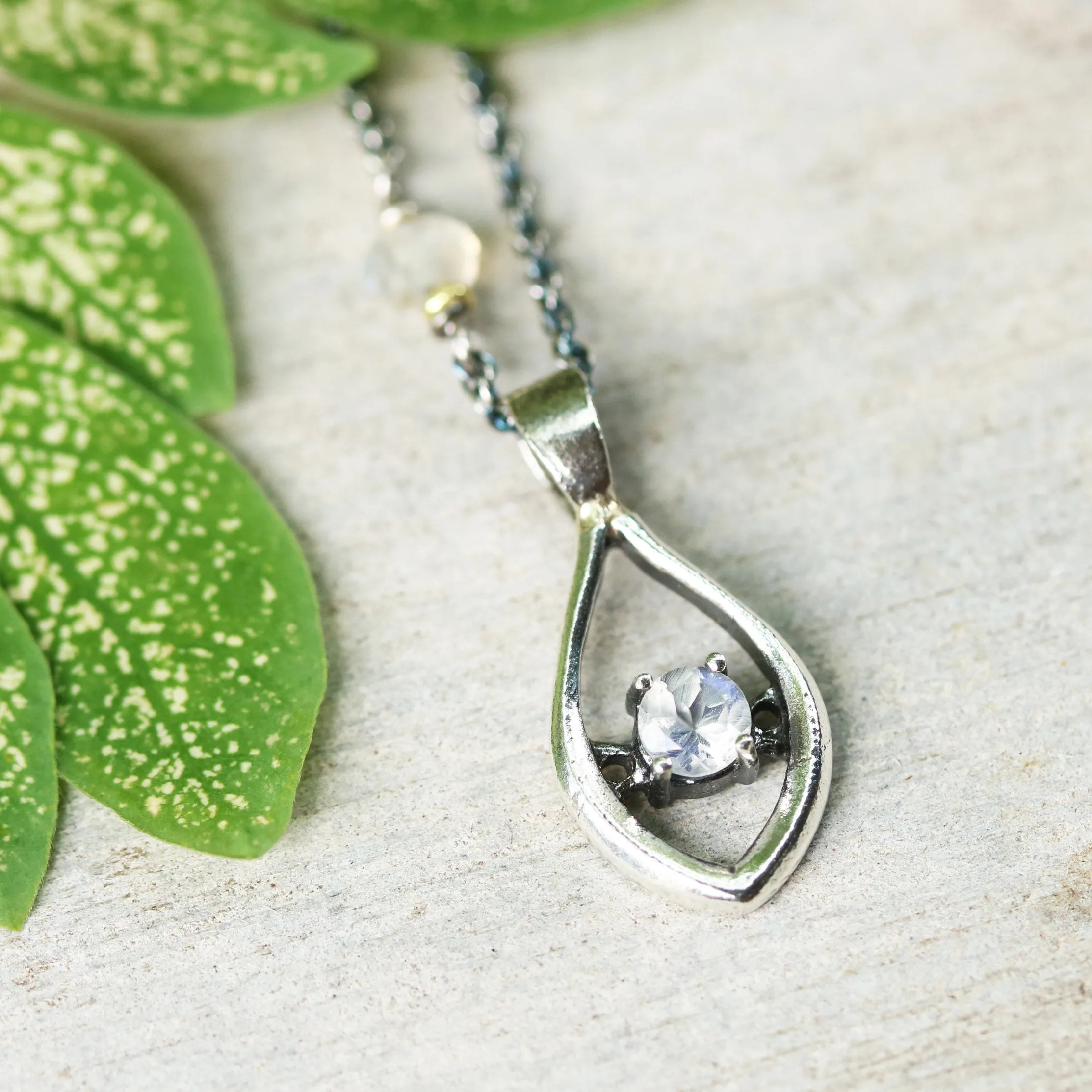 Silver leaf shape necklace and round faceted moonstone at the center with moonstone beads secondary on oxidized sterling silver chain