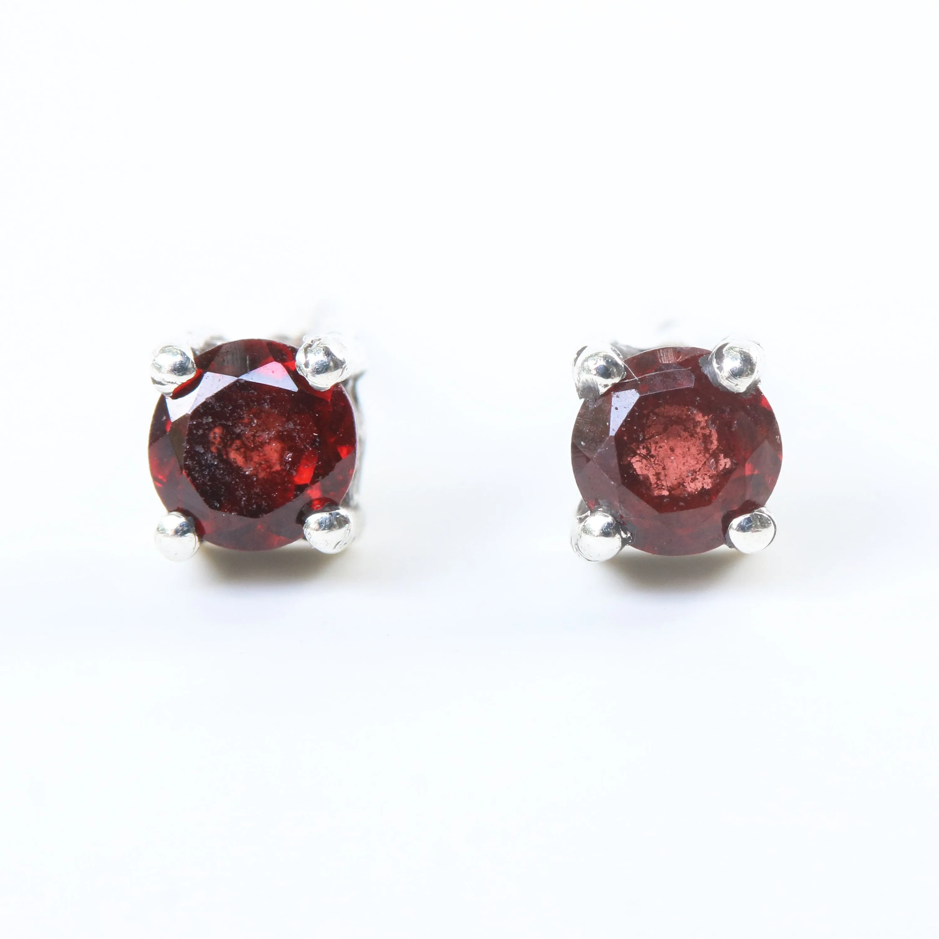 Sterling silver stud earrings with faceted garnet in prongs setting with sterling silver post and backing