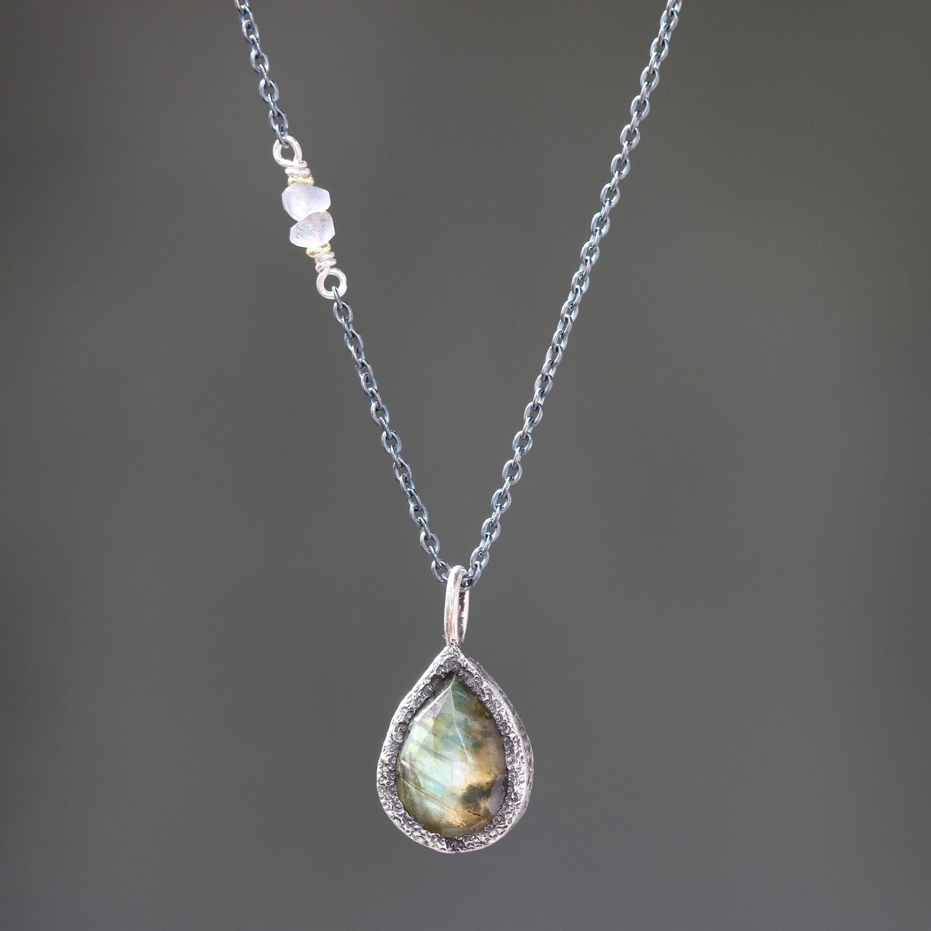 Teardrop faceted labradorite gemstone pendant necklace in silver bezel setting and labradorite beads on the side with silver chain
